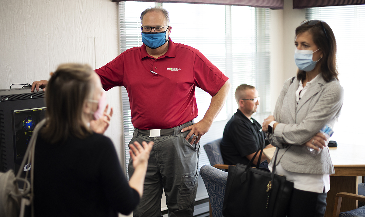 Photo: people wearing masks, talking about airport equipment